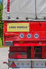 Fototapeta na wymiar Long Vehicle Caution Speed Limit Stickers at Cargo Truck Trailer End