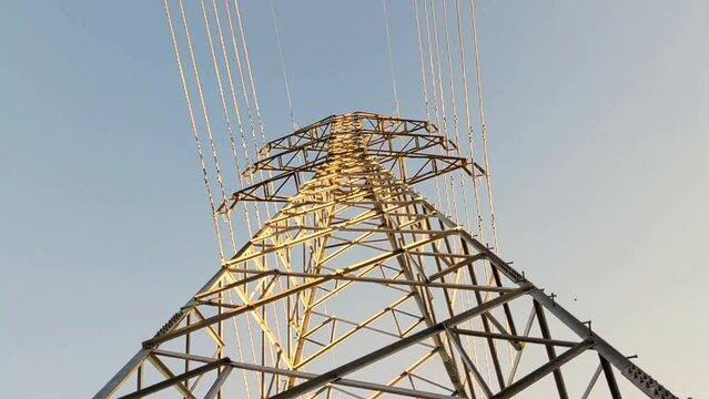 Low angle cinematic shot on the structure of a high voltage power pylon viewed from below