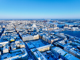 Fototapeta na wymiar Aerial view of the south of Helsinki with the Cathedral in the background and the Kalasatama towers during winter and snowy rooftops