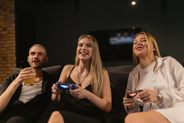 Ladies with blonde hair participate in console gaming at club. Exciting competition of women grabs attention of enthusiastic gamer