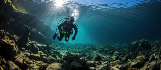 a diver with full scuba equipment performs in the deep blue sea - obrazy, fototapety, plakaty