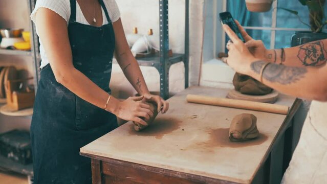 Woman, phone and team with clay in small business for pottery or molding art at workshop. Female person and colleague recording in store for creation, creativity or startup together with ceramics