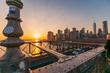beautiful sunset over manhattan with manhattan and brooklyn bridge.  Brooklyn Bridge illuminate at night with skyscrapers behind - obrazy, fototapety, plakaty