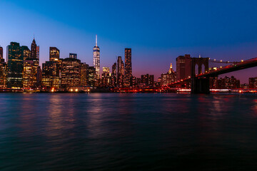  Brooklyn Bridge with lower Manhattan skyline in New York City at night, USA. Long exposure at night