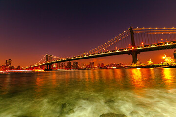 Brooklyn Bridge with lower Manhattan skyline in New York City at night, USA. Long exposure at night - obrazy, fototapety, plakaty
