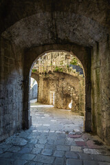 Fototapeta na wymiar Kotor Fortress. Stone archway and cobblestone path at Gurdic Bastion, showing rich texture and historic architecture. Kotor, Montenegro