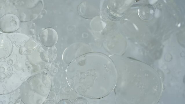 Top View, Oil Poured into Water and Splitting into Multiple Spheres and Bubbles in Water.