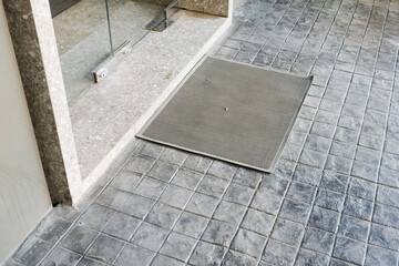 Gray soft carpet before the door at restaurant,doormat on floor,copy space for text,Home interior design.