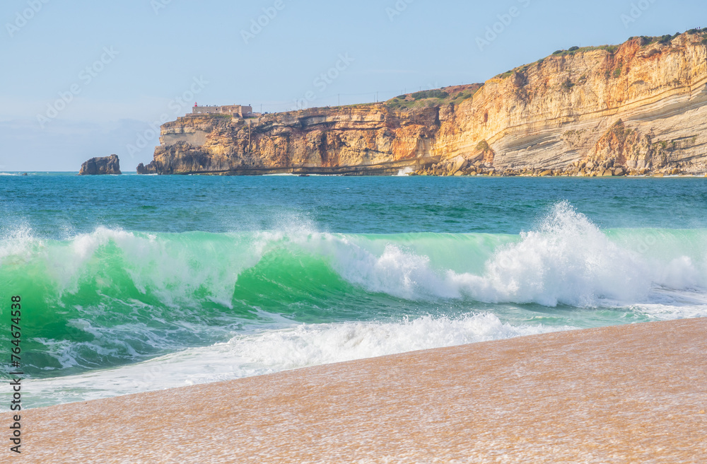 Wall mural wave and cliffs in atlantic ocean on the beach in nazaré, portugal