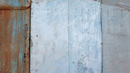 Rustic Elegance: Weathered Blue Metal Door. The Allure of Faded Paint and Oxidized Surfaces in an Industrial Setting