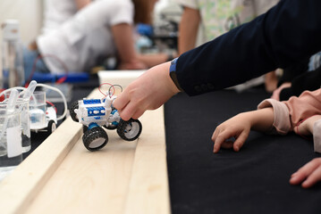 Robotics. A child's hand plays with a car