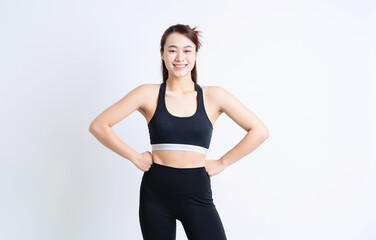 Young Asian woman wearing sportswear on white background