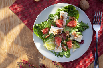 Salad plate with fork and knife on the table. Morning natural light. Top view