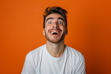 Fototapeta premium A man makes funny, sad, horrible grimaces, makes a face on a coloured background