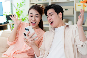 Photo of young Asian couple at home