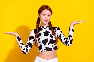 Zelfklevend Fotobehang Photo of doubtful thoughtful lady dressed cowskin top comparing arms empty space isolated yellow color background © deagreez