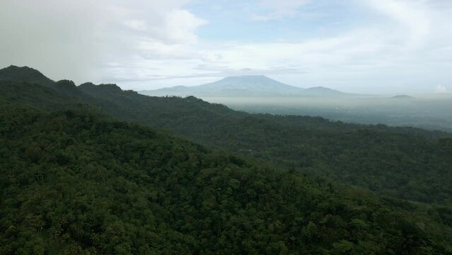 Cinematic aerial shot of an endless mountain and forest landscape in Indonesia. Tropical landscape.