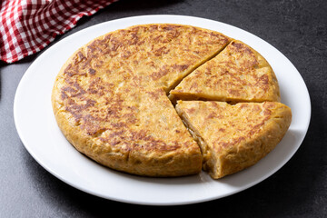 Traditional spanish omelette on black background