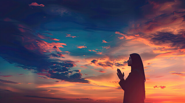 Silhouette of woman praying over beautiful sky background.