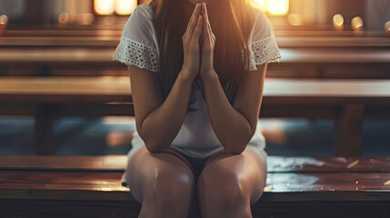 woman knee down and praying in church in the morning Christian teenager woman hand praying Hands folded in prayer on the wooden seat in the morning concept for faith, spirituality and religion. - obrazy, fototapety, plakaty