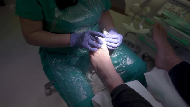 The podiatrist bandages the thumb with a bandage, profession of podiatrist 