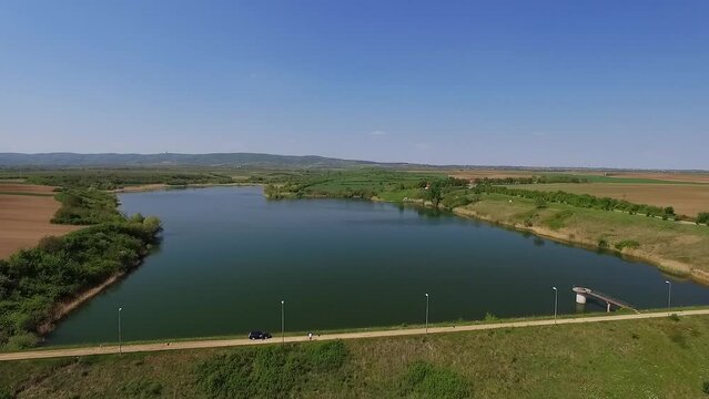 Idyllic aerial footage of clean lake under clear blue sky in countryside