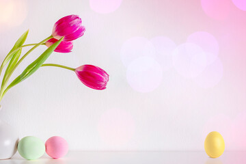 Spring pink tulip flowers with Easter eggs on pink background
