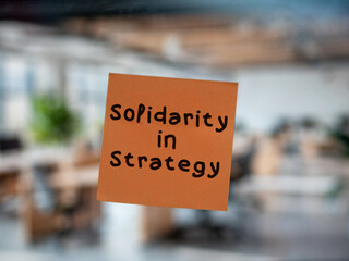 Post note on glass with 'Solidarity in Strategy'.