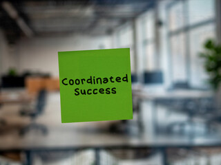 Post note on glass with 'Coordinated Success'.