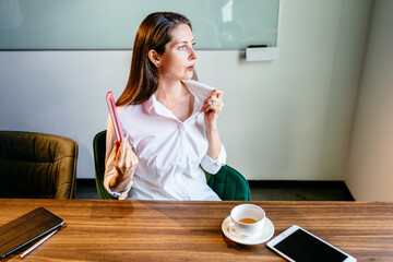 A menopausal business woman having a hot flush. Exhausted mature woman wear white shirt in...