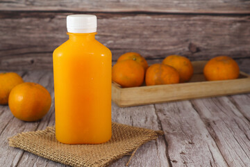 Orange juice in a bottle and oranges placed in a fruit tray.