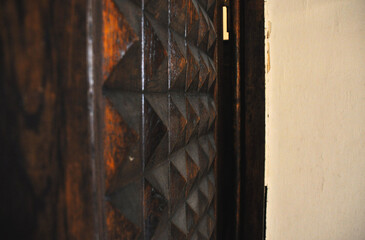 a detailed view of a part of a wooden door with intricate geometric patterns, emphasizing the...