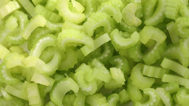 Chopped celery stalks, rotation in circle. green fresh celery, Turning. selective focus. green background
