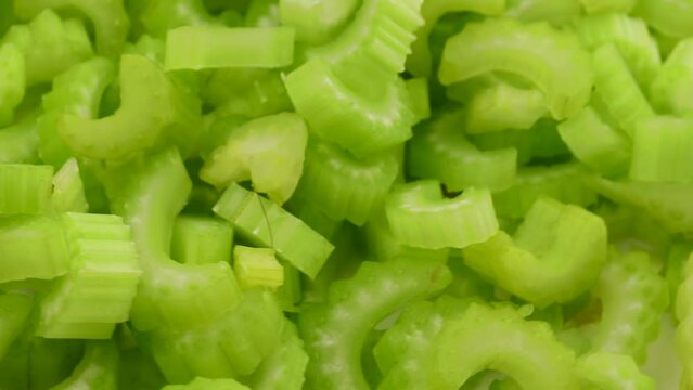 Chopped celery stalks, rotation in circle. green fresh celery, Turning. selective focus. green background