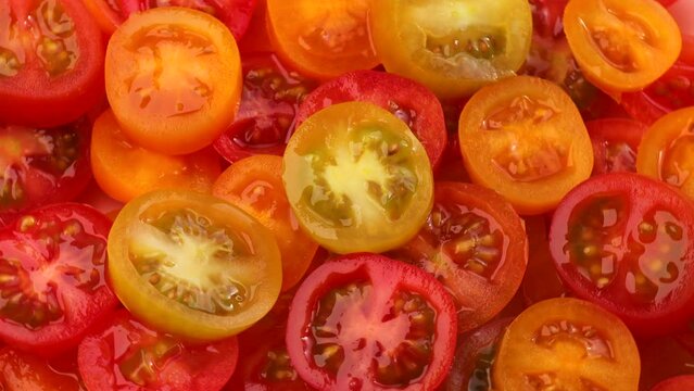 red and yellow cherry tomato slices, rotation in circle. slice tomato, Turning. selective focus. bright background