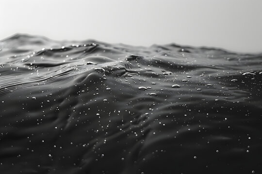 a black and white photo of the surface of a large body of water with small dots of water on it.