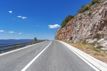 Mountain highway with blue sky and sea on a background
