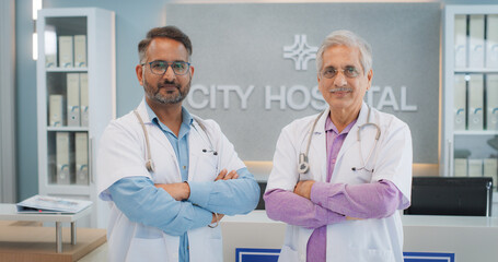 Portrait of Two Male Indian Doctors in a Hospital Smiling and Looking at the Camera. Medical...