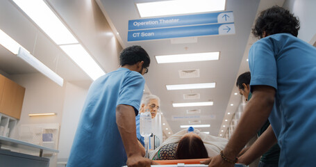 Backview Shot of Group of Medical Specialists Transporting an Elderly Patient with a Stretcher...