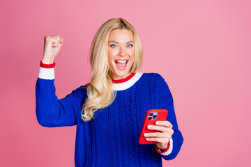 Photo of pretty lady hold apple iphone gadget raise fist empty space wear blue sweater isolated on...