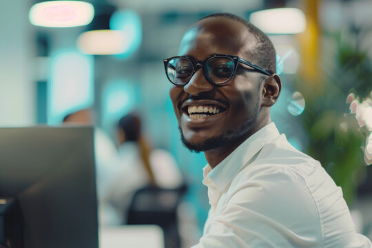 Businessman or worker smiling in front of computer in the office