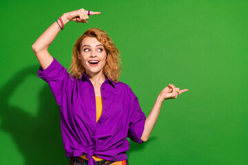 Photo portrait of pretty young girl point shocked excited empty space wear trendy purple outfit isolated on green color background