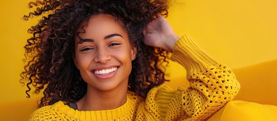 A joyful woman with curly hair smiling warmly while looking directly at the camera