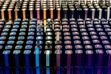 A large display case with many jars of nail polish of different colors, arranged in rows. The jars are arranged in such a way as to highlight their color and type. T