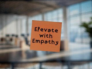 Post note on glass with 'Elevate with Empathy'.
