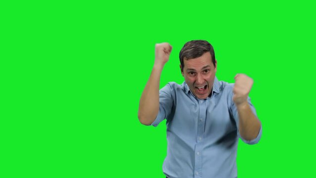 Young happy business man winner celebrating success showing hands gesture yes on green background