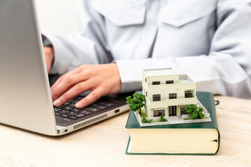 不動産についてラップトップで調べる女性