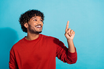Photo of indian model guy in red pullover directing finger empty space interested touching new...