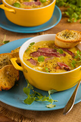 Traditional Polish pea soup. Prepared with smoked meat. Served in a yellow bowl with croutons. Home made.
