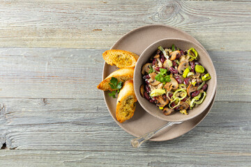 Spring salad with red beans and mushrooms. Served with croutons and garlic butter.